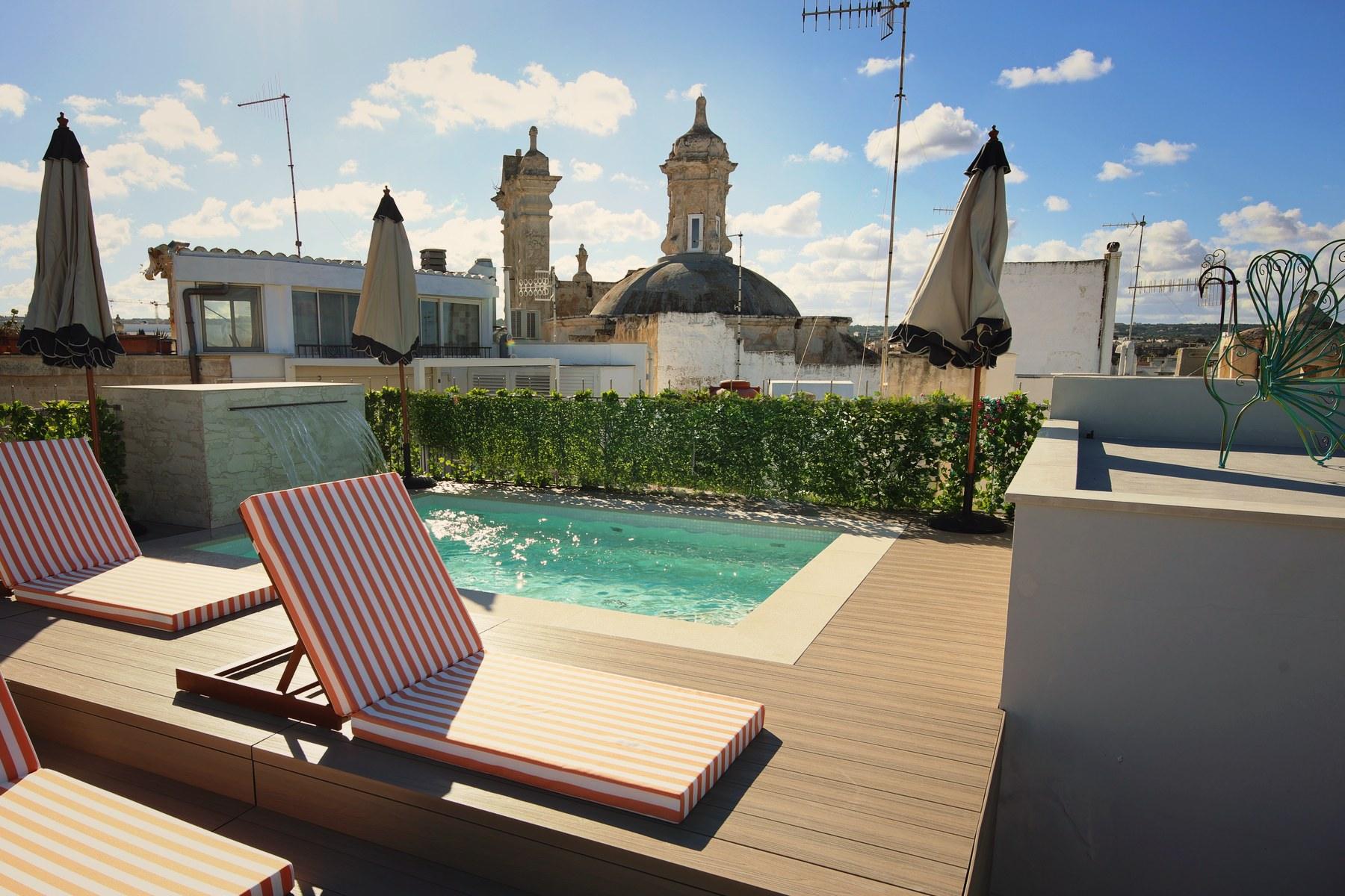 Sun loungers and parasols on the rooftop terrace, set for an afternoon above the old town.